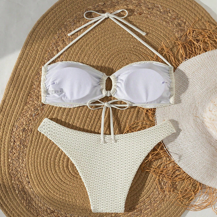 Somrig damtriangelbikini i crème med trendig knutdetalj. Idealisk för strand & pool, stilrent badmode.