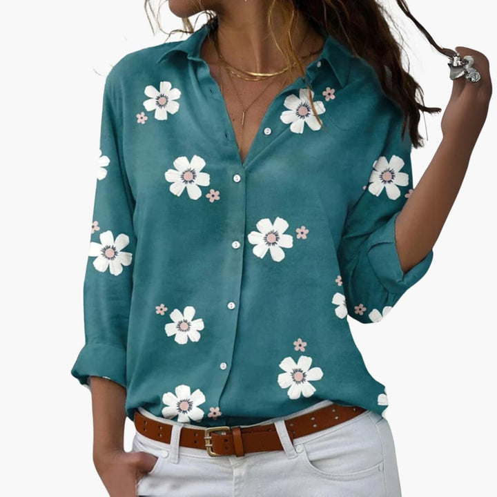 Elegant dam sommarblus i mjukt tyg med livfullt blommönster och korta ärmar för varma dagar.