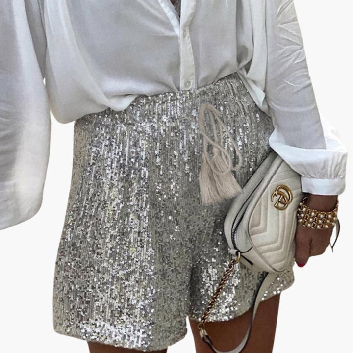 Elegant silverfärgad paljetshorts för kvinnor med hög midja. Skimrande damshorts för en chic och festlig look.