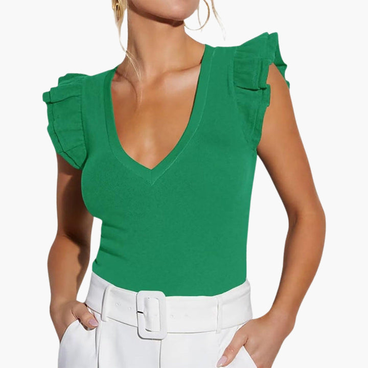 Elegant damtopp med V-ringning, ärmlös design och volangaxlar. Idealisk för fest eller vardagsmode.
