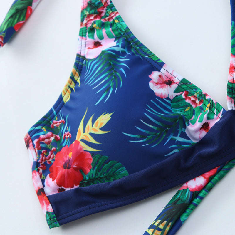 "Kvinnors sommarblommig bikiniset framifrån, livlig blommig design i blå och vit för strand och pooldagar."