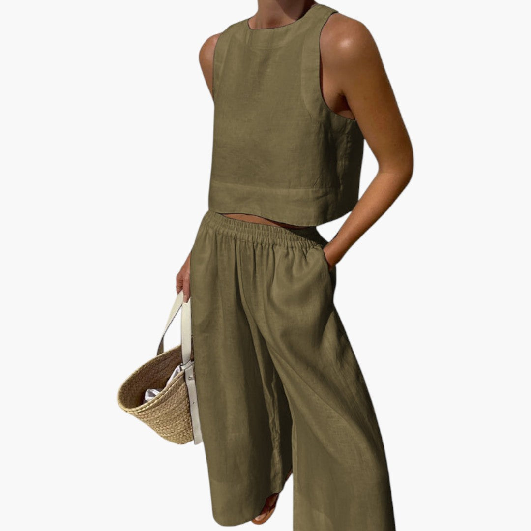 Kvinna bär tvådelat set: Ärmlös crop top och vida byxor. Visar modern passform och stil.