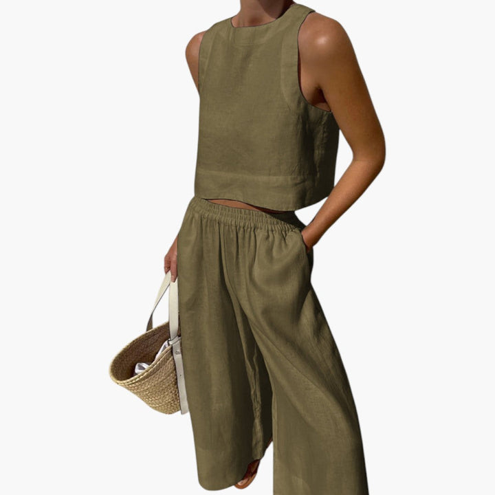 Kvinna bär tvådelat set: Ärmlös crop top och vida byxor. Visar modern passform och stil.
