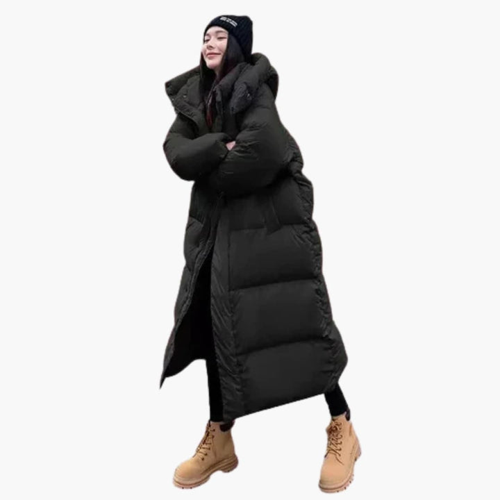 Bekväm, lång quiltad damjacka med huva. En modern pufferjacka som håller dig varm under vintern.