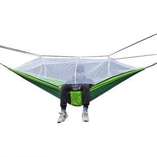 Grön lättviktshängmatta med finmaskigt myggnät, perfekt för avkoppling under camping och vildmarksliv.