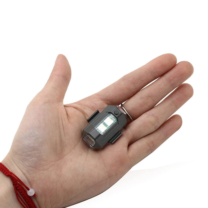 LED-stroboskopljus med 4 färger, USB-laddning, för fordon. Visas i regnbågens färger på svart bakgrund.