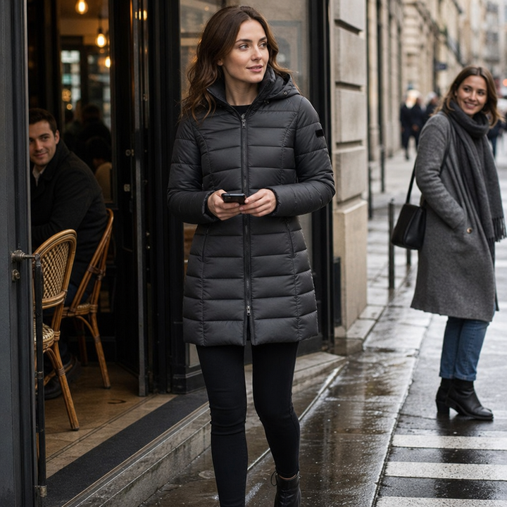 Damernas långa quiltade vinterjacka med huva sedd framifrån i trendig design