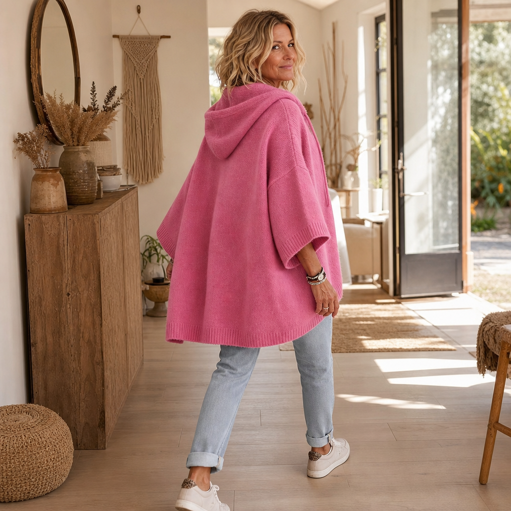 Modell bärande rosa stickad hoodie med huva och relaxed passform