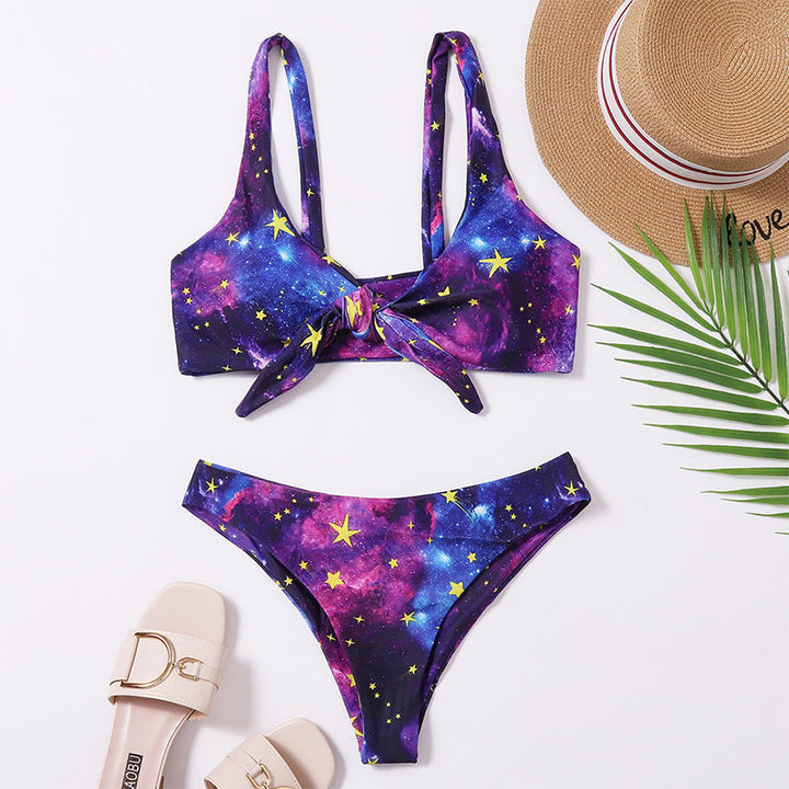 Lila triangelbikini för dam med galaxmönster och trendig knutdetalj, perfekt för sommar och strand.