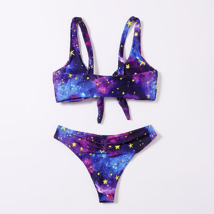 Elegant damtriangelbikini i lila med unikt galaxmönster, knutdetalj och bekväm design för simning.