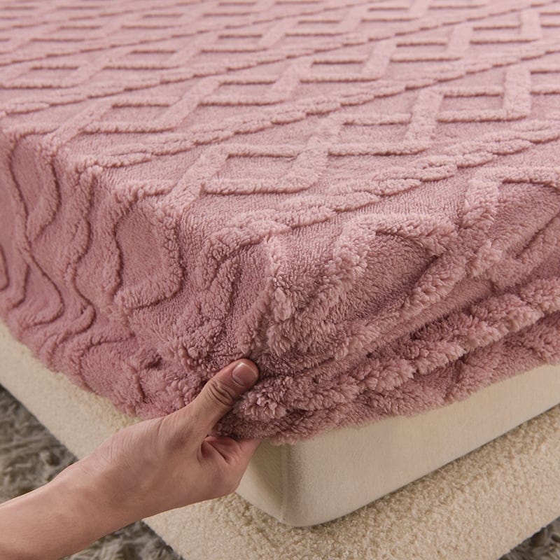 Rosa texturerat spännlakan som dras över madrassens hörn