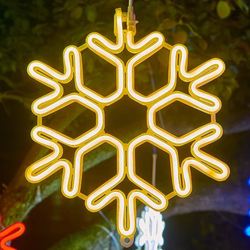 Lysande LED-snöflingor som juldekoration hängande från trägrenar i trädgården