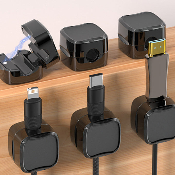 "Magnetisk kabelhållare håller kablar organiserade, stilren design i svart och vit, passar kablar upp till 7 mm."