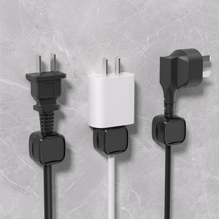 "Magnetisk kabelhållare håller kablar organiserade, stilren design i svart och vit, passar kablar upp till 7 mm."