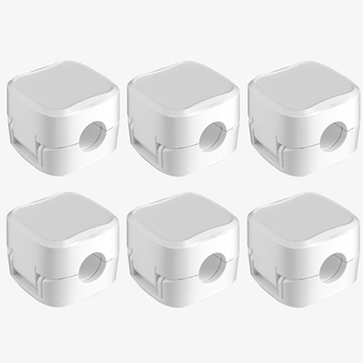 "Magnetisk kabelhållare håller kablar organiserade, stilren design i svart och vit, passar kablar upp till 7 mm."