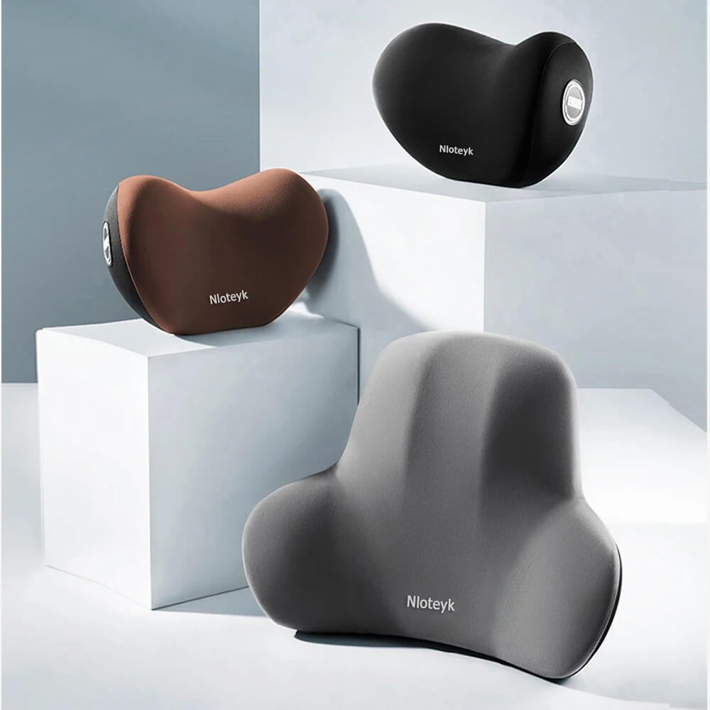 Tre olika färger av ergonomiska nack- och ryggkuddar i memory foam uppställda på display