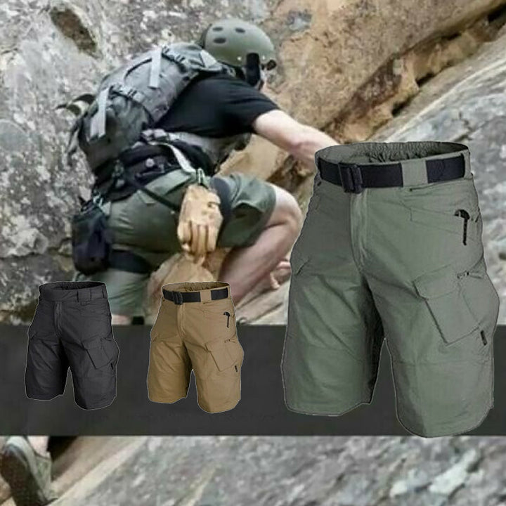 Man i militärgröna taktiska shorts klättrar i stenig terräng