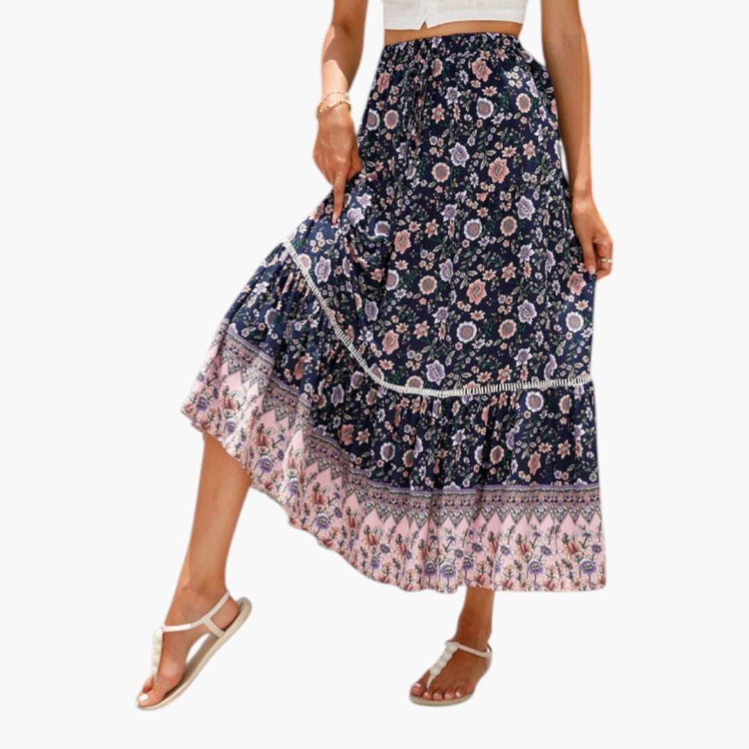 Modell bär elegant tryckt midi-kjol med volanger och elastisk midja, passande för vardag.