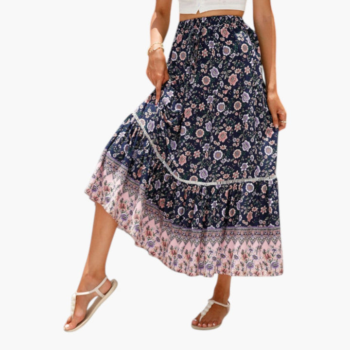 Modell bär elegant tryckt midi-kjol med volanger och elastisk midja, passande för vardag.
