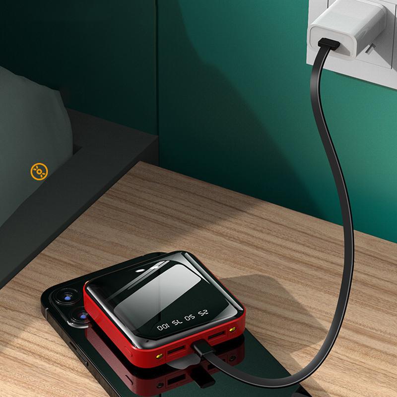 "Mini powerbank med spegelyta, externa kablar; kompakt, elegant design för enkel laddning av enheter på språng."