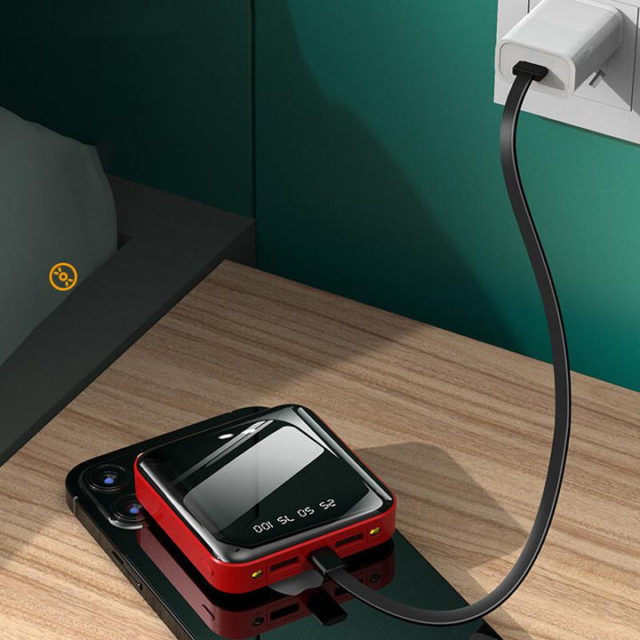 "Mini powerbank med spegelyta, externa kablar; kompakt, elegant design för enkel laddning av enheter på språng."