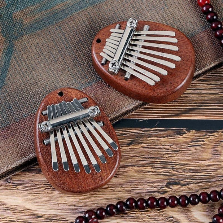Mini Tum-piano i trä och kristall med graverade tangenter. Enkel att spela, bärbar och perfekt som present.