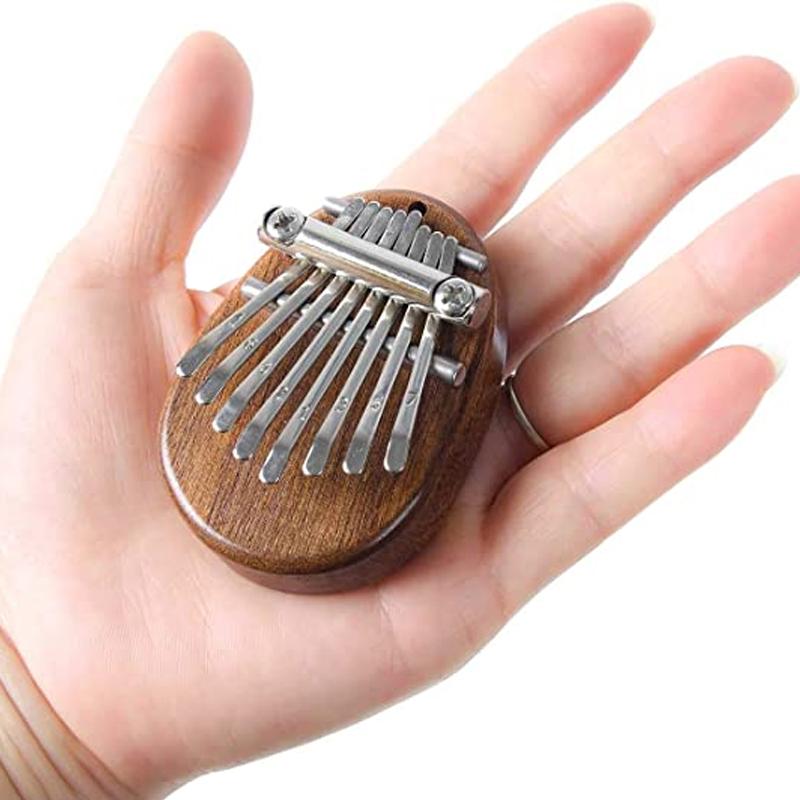 Mini Tum-piano i trä och kristall med graverade tangenter. Enkel att spela, bärbar och perfekt som present.