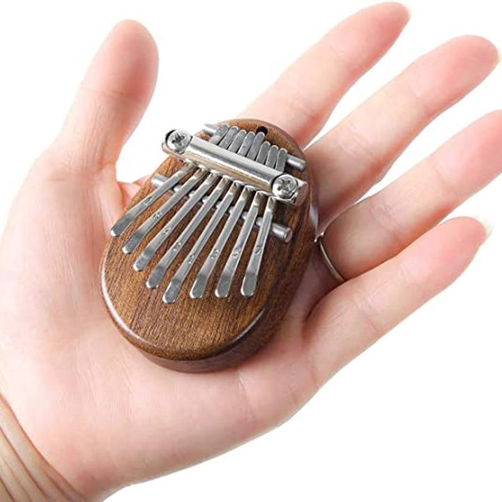 Mini Tum-piano i trä och kristall med graverade tangenter. Enkel att spela, bärbar och perfekt som present.