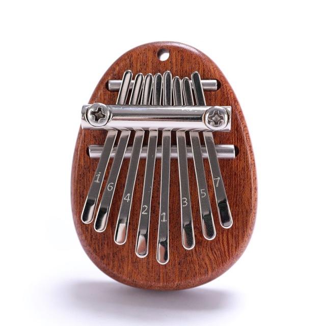 Mini Tum-piano i trä och kristall med graverade tangenter. Enkel att spela, bärbar och perfekt som present.