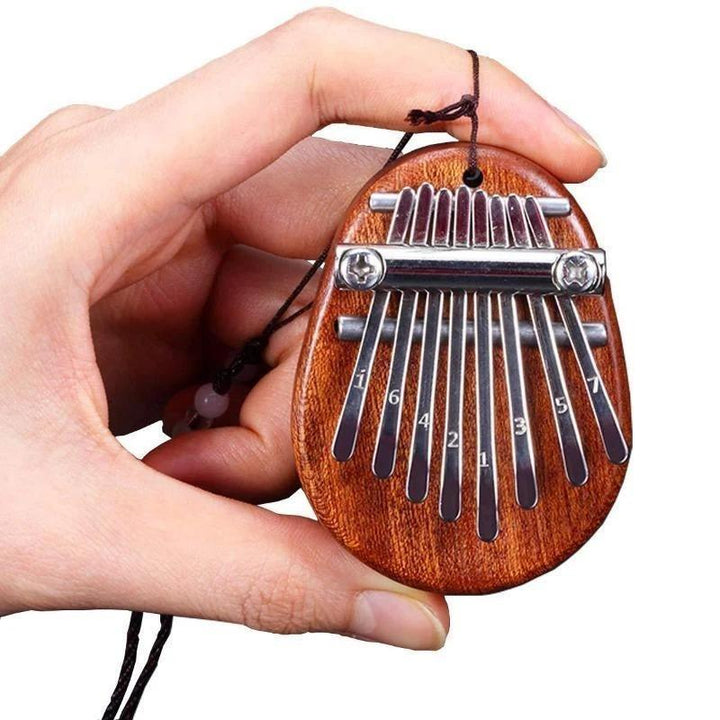 Mini Tum-piano i trä och kristall med graverade tangenter. Enkel att spela, bärbar och perfekt som present.
