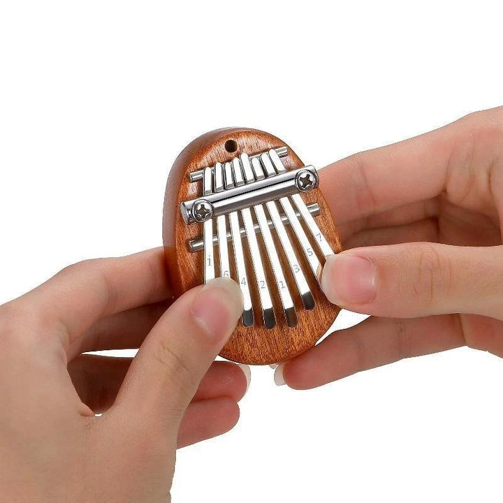 Mini Tum-piano i trä och kristall med graverade tangenter. Enkel att spela, bärbar och perfekt som present.