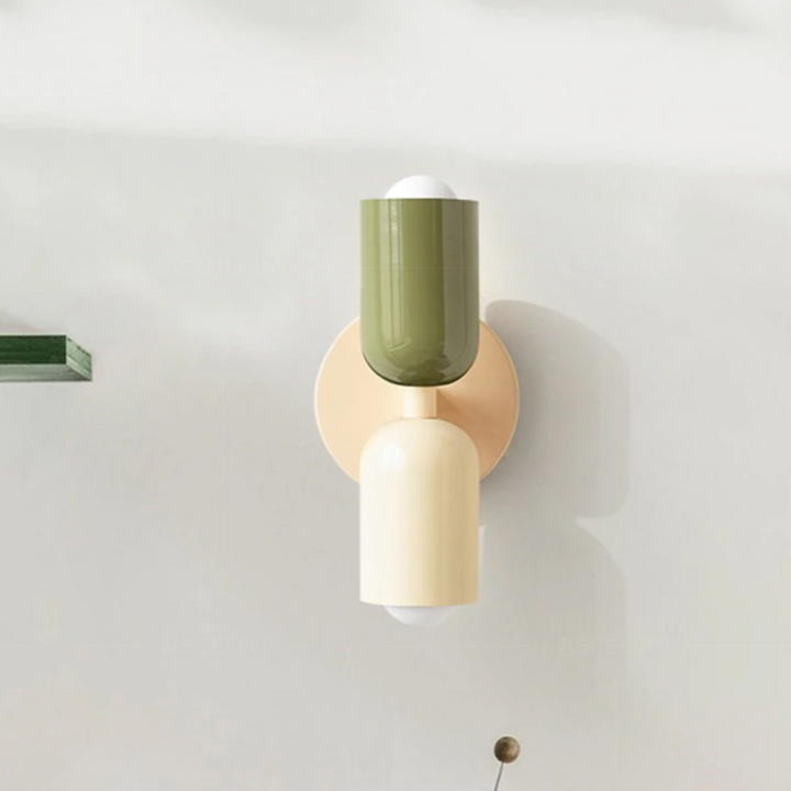 Minimalistisk vägglampa i gröna och beige toner mot ljus vägg [[lstfy-media:1]]