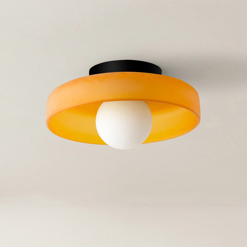 Orange rund taklampa med frostad ljuskälla i nära bild
