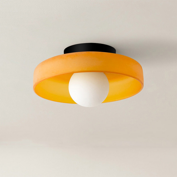 Orange rund taklampa med frostad ljuskälla i nära bild