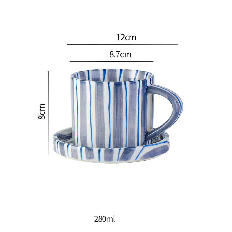 Handritat minimalistiskt koppset i keramik. Randig kaffekopp och tallrik för en modern teservis.
