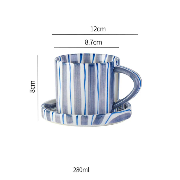 Handritat minimalistiskt koppset i keramik. Randig kaffekopp och tallrik för en modern teservis.