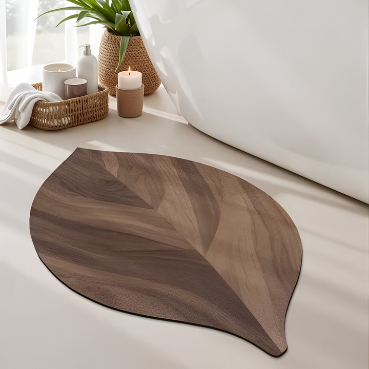Oval badrumsmatta i polyester med modern lövdesign, snabbtorkande och vattenabsorberande.
