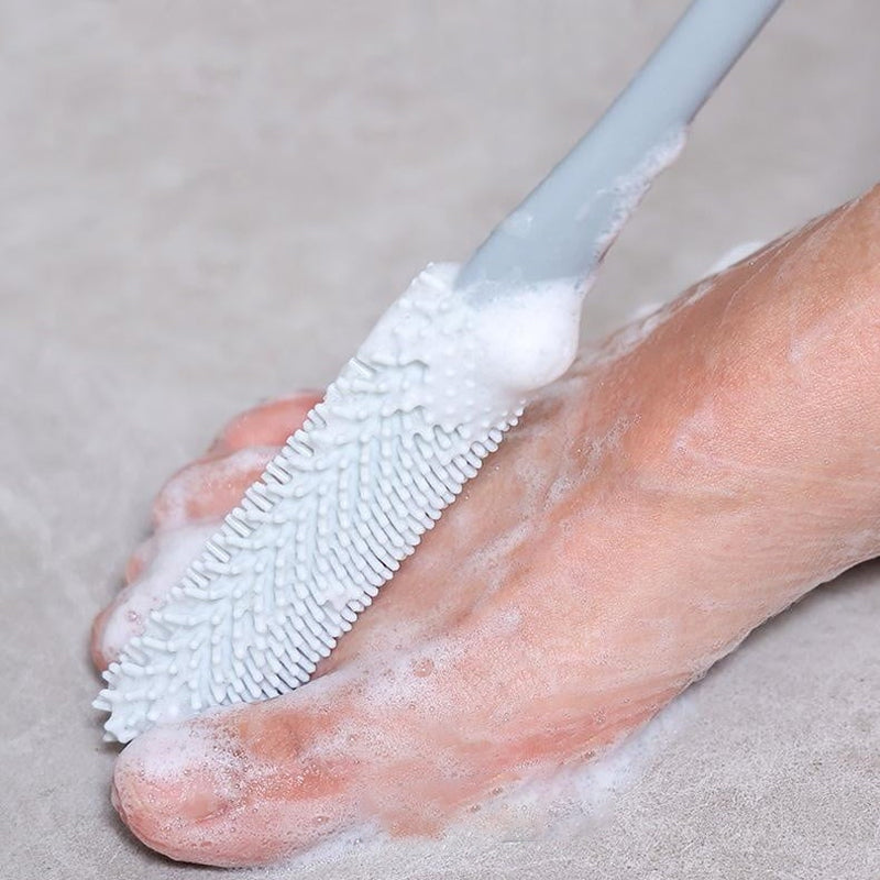 Mjuk grå ergonomisk tåborste med skonsamma borst, perfekt för effektiv fotvård.