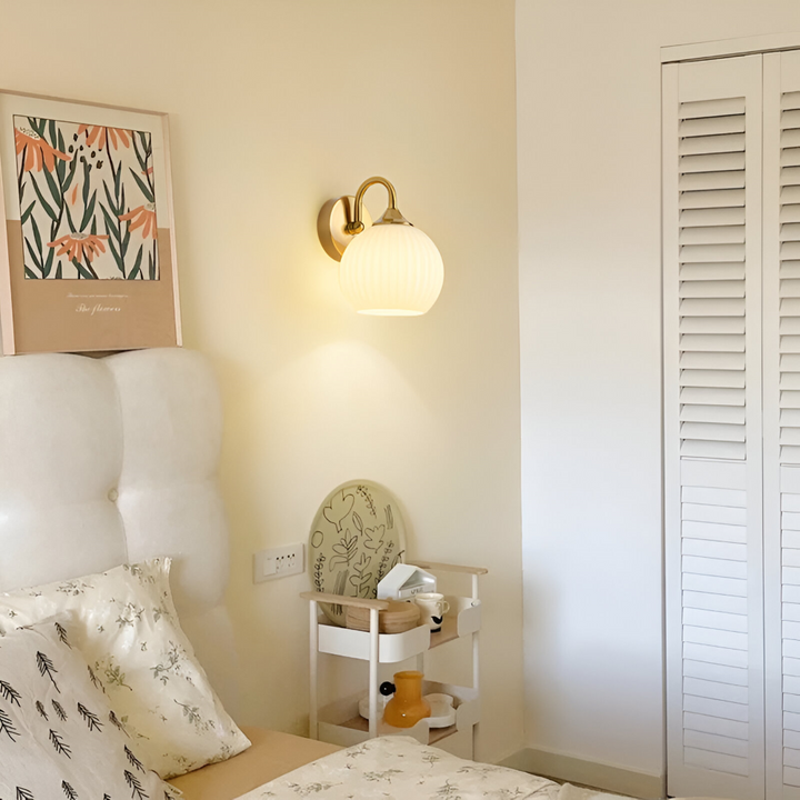 Stilren LED-vägglampa i glas, klotformad med randigt mönster för heminredning.