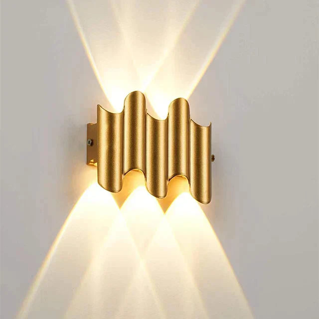 Minimalistisk vägglampa i svart med guldfärg. LED-ljus för effektiv upp/ner-belysning.