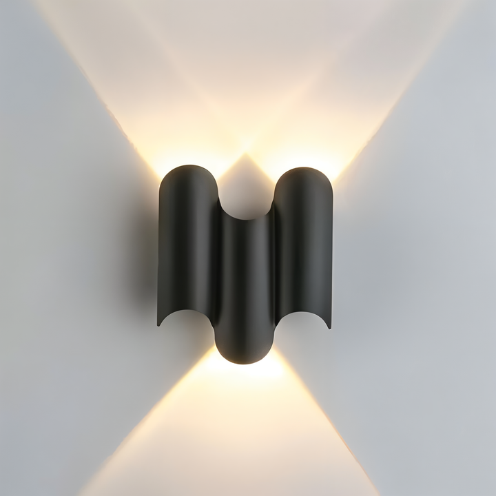 Stilren svart vägglampa med guldaccent. LED-teknik ger energisnål upp/ner-belysning i hemmet.