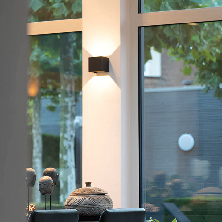 Nordisk LED-vägglampa med varmvitt ljus, modern och stilren inredningsdetalj för sovrum eller hall.