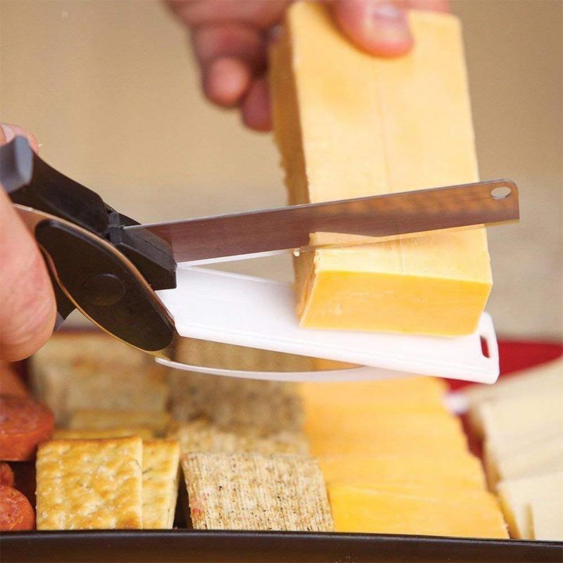 "Multifunktionell grönsaksax med rostfritt stålblad och svart handtag, inbyggd skärbräda för enkel skärning av mat."