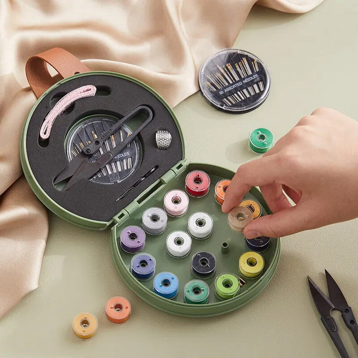 "Multifunktionell handhållen sömnadssats i beige och grön med nålar och trådar i en kompakt, lätt design."