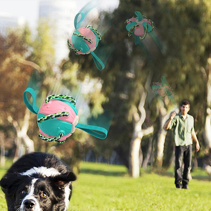 "Multifunktionell tuggig UFO-boll för hundträning med färgglada rep och gummiyta, perfekt för interaktiv lek utomhus."