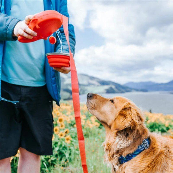 "Multifunktionellt hundkoppel med röd skål, blått band, inbyggd vattenbehållare och avfallspåsar för små och stora hundar."