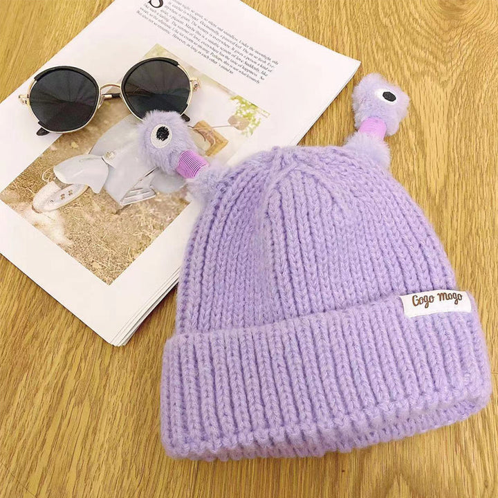 En charmig presentförpackning som innehåller en stickad monsterhatt.