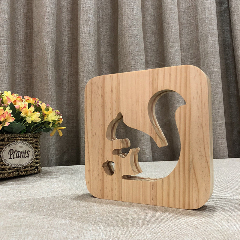 Nattlampa i trä med snidad design, avger varmt sken, perfekt för sovrum eller dekoration.