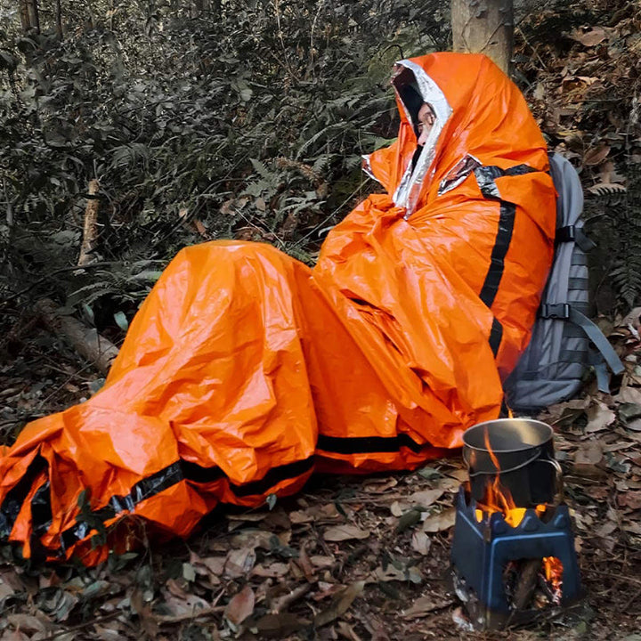 "Nödsovsäck utomhus, vattentät och kompakt i orange, för camping och äventyr, synlig vid nödsituationer."