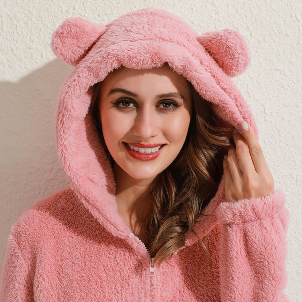 Kvinna i rosa onesie med öron på huvan